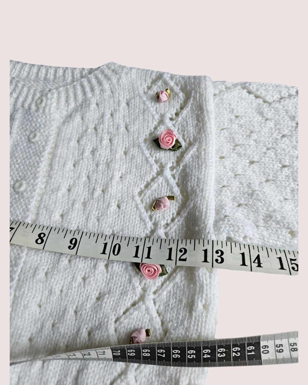 Handknit cardigan with rosettes